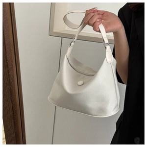Détail d'un sac demi-lune en tissu Oxford blanc porté sur une tenue noire