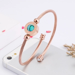 Detail of rose gold rope cuff bracelet with abalone shell inlay and Roman numerals
