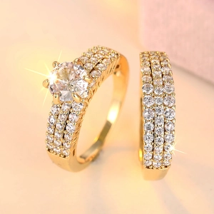Luxury gold engagement ring set with four-prong center stone and pavé diamond bands