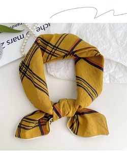 Close-up of cotton linen square scarf showing yellow plaid pattern and fine white stitching