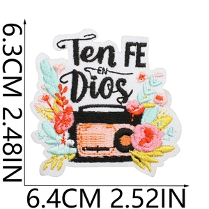 Detail of vintage radio and floral embroidery patch with Ten FE EN Dios text and sizing
