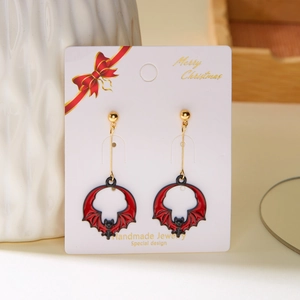 Detail of red flower and black skull Halloween earrings on a holiday card