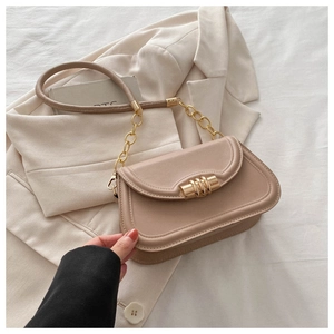 Detail of minimalist pink saddle bag with golden triple cylinder lock and chain strap