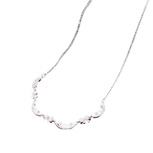 Silver bow and crescent moon pendant necklace with white zircons on a white background