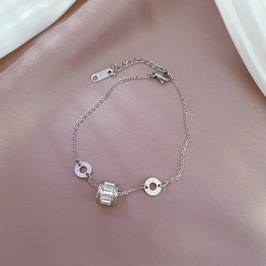 Détail macro du bracelet en acier titane argenté avec chiffres romains et pendentif zircon