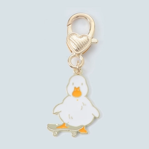 Detail of cartoon duck on skateboard keychain with heart-shaped gold lobster clasp