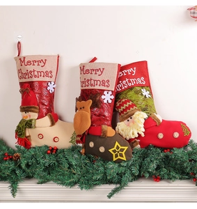 Close-up of three 3D Christmas stockings with Santa, Snowman and Reindeer on fireplace
