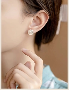Close-up of geometric double-layer lotus pearl stud earring worn on model ear