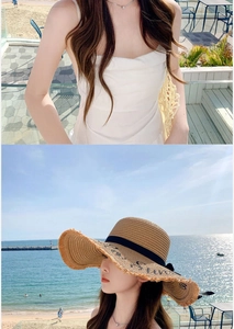 Detail of straw sun hat with Sun embroidery and a white summer beach dress