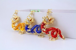 Detailed close-up of three enamel Chinese dragon keychains in red, blue and yellow colors