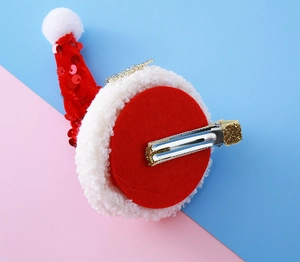 Détail de la pince crocodile dorée scintillante sur une épingle à cheveux de Noël à paillettes