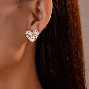 Close-up of heart-shaped lace cutout stud earrings with zircon in polished silver finish