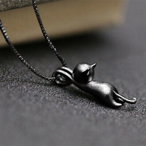 Macro shot of matte black kitten pendant necklace with textured metal surface detail