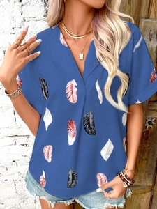 Detail of blue summer shirt featuring white and pink feather patterns and a V-neckline