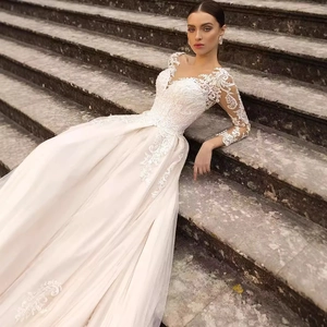 Ivory lace long-sleeve wedding dress with deep V-neck and elegant tulle skirt flow