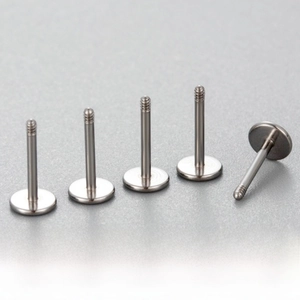 Detailed macro view of 0.8mm and 1.2mm titanium steel flat back ear piercing studs