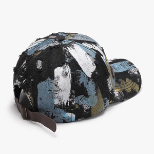 Distressed black denim baseball cap with abstract paint splatters and leather strap back