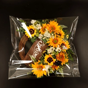 Dettaglio ghirlanda di girasoli con targa Welcome in confezione trasparente