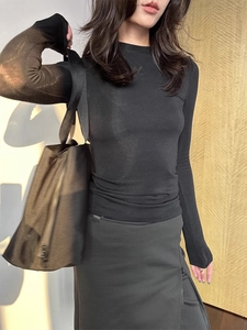 Detailed view of women's black slim-fit wool-tencel long sleeve top with textured fabric