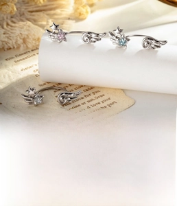 Detailed view of silver star and wing ear studs with pink and blue zircon accents