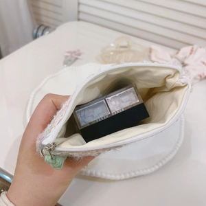 Dettaglio del rivestimento e capacità della mini borsa intrecciata con cerniera a fiore