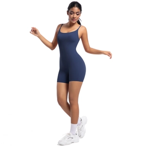 Deep blue yoga romper with thin straps and U-neckline shown on a model against white background