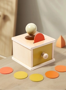 Detail of wooden Montessori coin box with yellow drawer and colorful sorting pieces