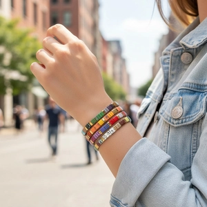 Detail of colorful Tila tile beads and layered bohemian bracelets on a woman's wrist