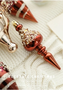 Close-up of champagne droplet Christmas ornaments with white sequins on a knit background