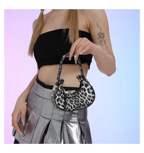 Detail view of the crescent underarm bag featuring a classic black and white leopard print