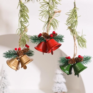 Christmas metal double bells with pine cones and red berries hanging on rustic hemp rope
