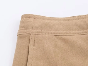 Détail du tissu en maille kaki montrant des coutures précises et une taille côtelée