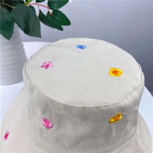 Close-up of delicate floral embroidery on a beige cotton sun hat for women