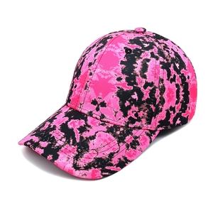 Detail of pink and black tie-dye baseball cap with curved brim and twill cotton texture