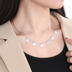 Silver stainless steel necklace with multiple round disc charms worn by a female model