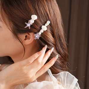 Détails des barrettes étoile de mer et fleur avec perles et coquillages sur modèle