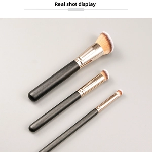 Detailed view of foundation and concealer brush set with black handles and gold ferrules