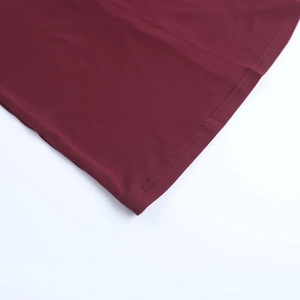 Detailed close-up showing fine double-needle stitching on wine red knitted dress fabric