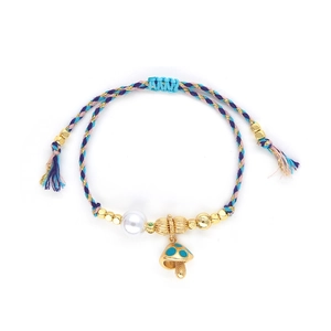 Detail of colorful woven rope bracelet with gold beads, pearl and blue mushroom charm