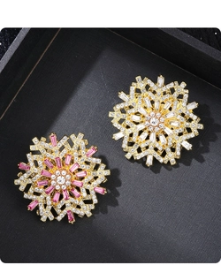 Detailed close-up of exquisite snowflake brooches with pink and white rhinestones in a box