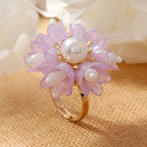Macro detail of a 3D purple floral ring with white pearls and adjustable gold band