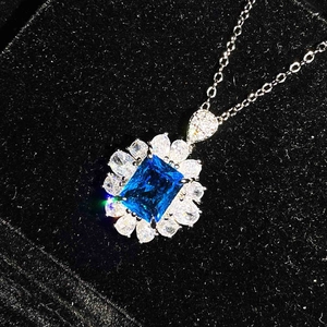 Detailed close-up of a silver necklace featuring a blue rectangular gemstone pendant