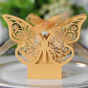 Macro detail of laser-cut gold butterfly candy box with delicate organza ribbon