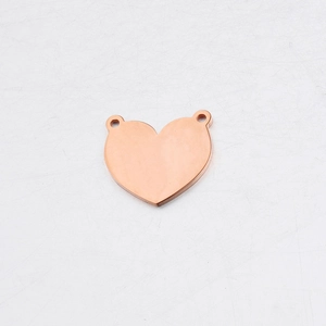 Detailed macro view of a rose gold heart pendant with two connector loops on white background