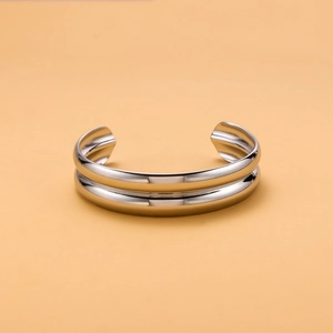 Detail shot of a minimalist double-layered polished silver stainless steel open bangle
