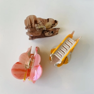 Close-up of acetate animal hair claws including Shiba Inu and butterfly designs