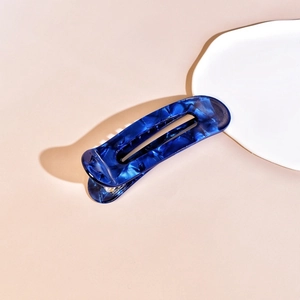 Close-up of a blue marble acetate hair claw clip with a polished tortoiseshell finish