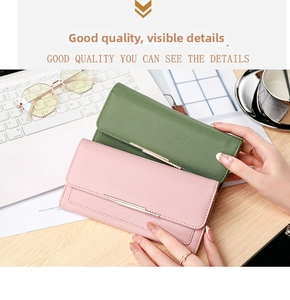 Detail of lychee pattern long wallets in green and pink on a stylish office desk