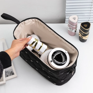 Quilted black organizer bag with white bows for hair dryer and travel toiletries