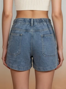 Detail shot of blue denim shorts back view showing elastic high waist and dual back pockets